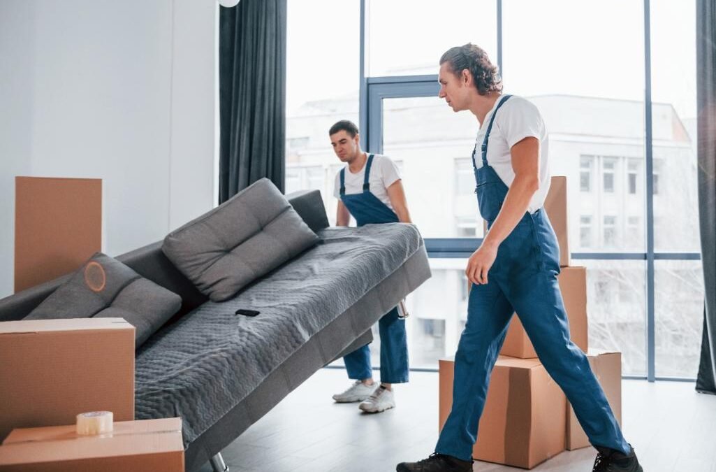 busy-day-two-young-movers-blue-uniform-working-indoors-room-1-1025×675